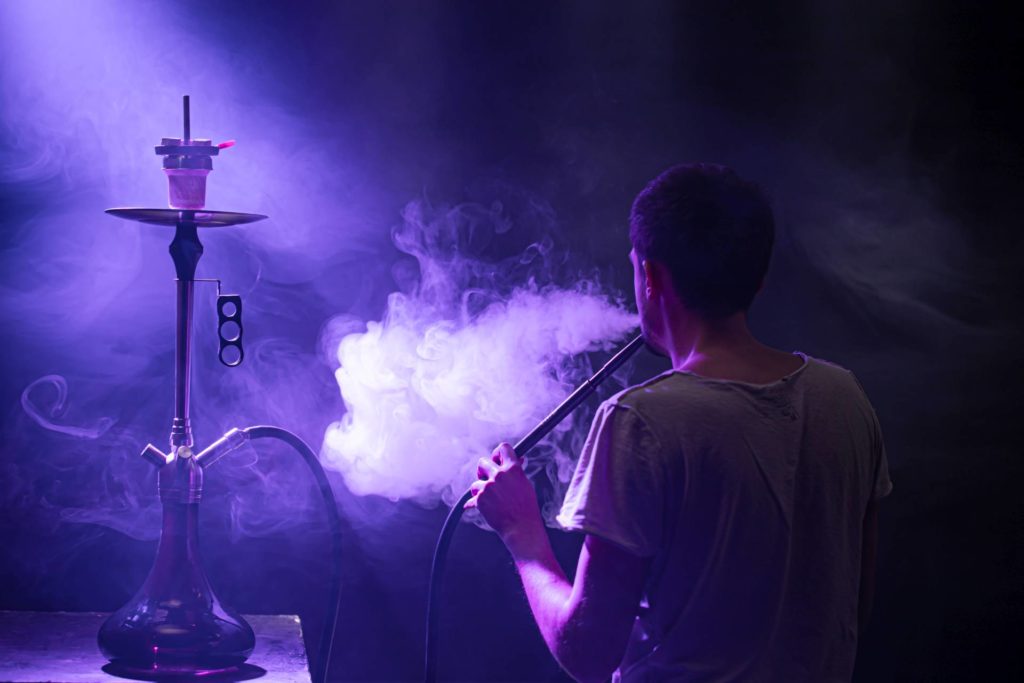 Ein Mann, der die klassische Shisha raucht