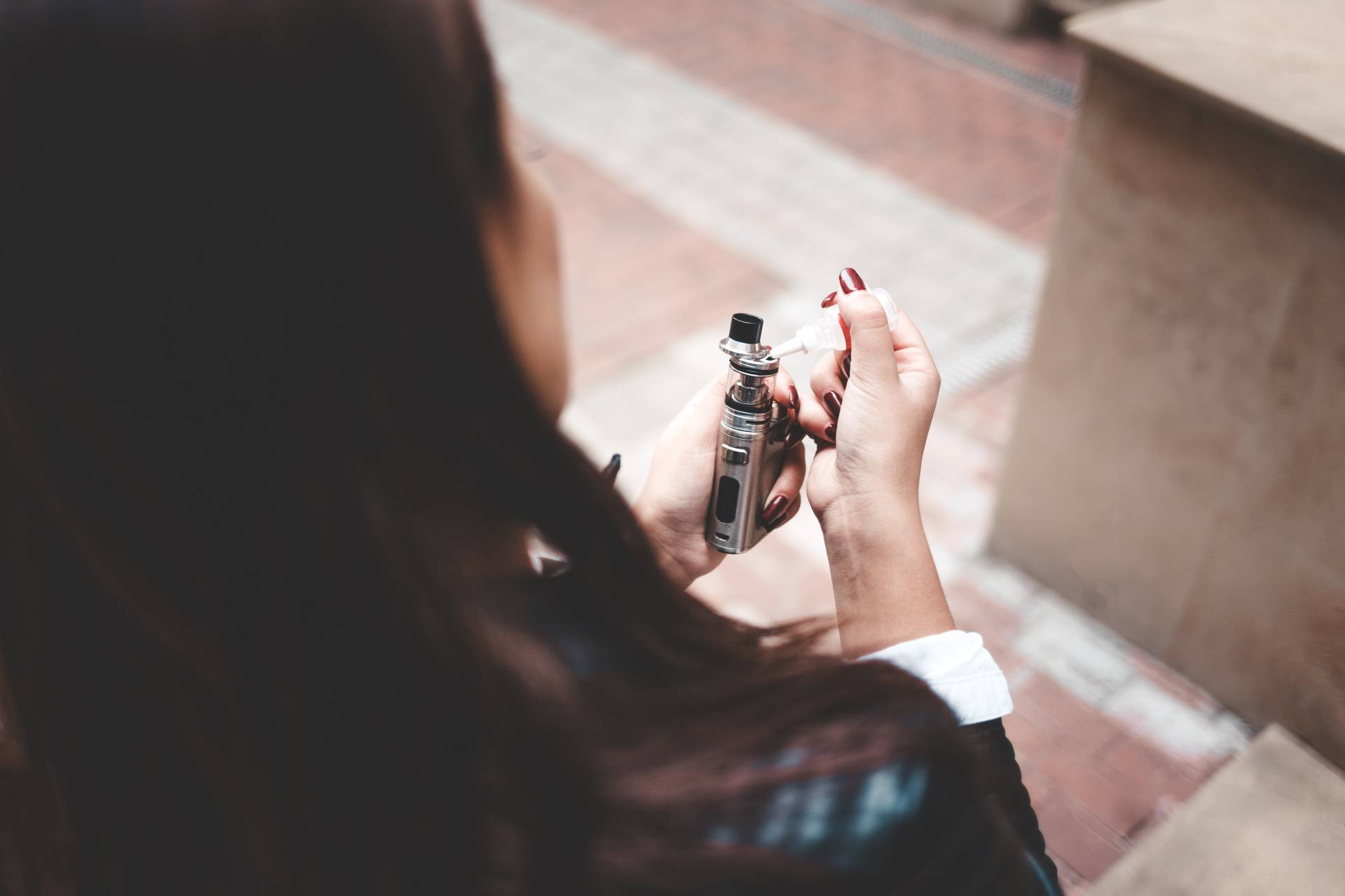 Eine junge Frau füllt Liquid in E-Zigaretten